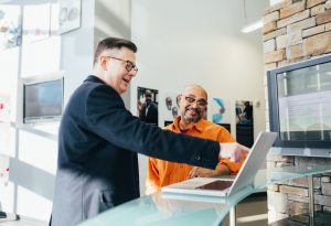 Two men looking at a laptop screen, hiring great sales candidates