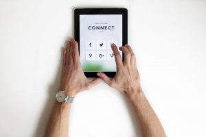 Someone holding a tablet with apps and marketing tools for franchisees