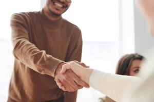 Two people shaking hands during an interview