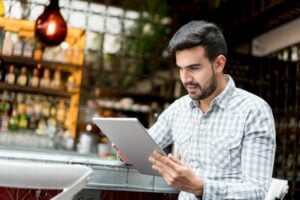 A man looking at job applicants on a tablet