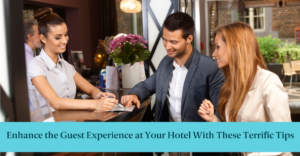 Hotel front desk staff happily helps two guests.
